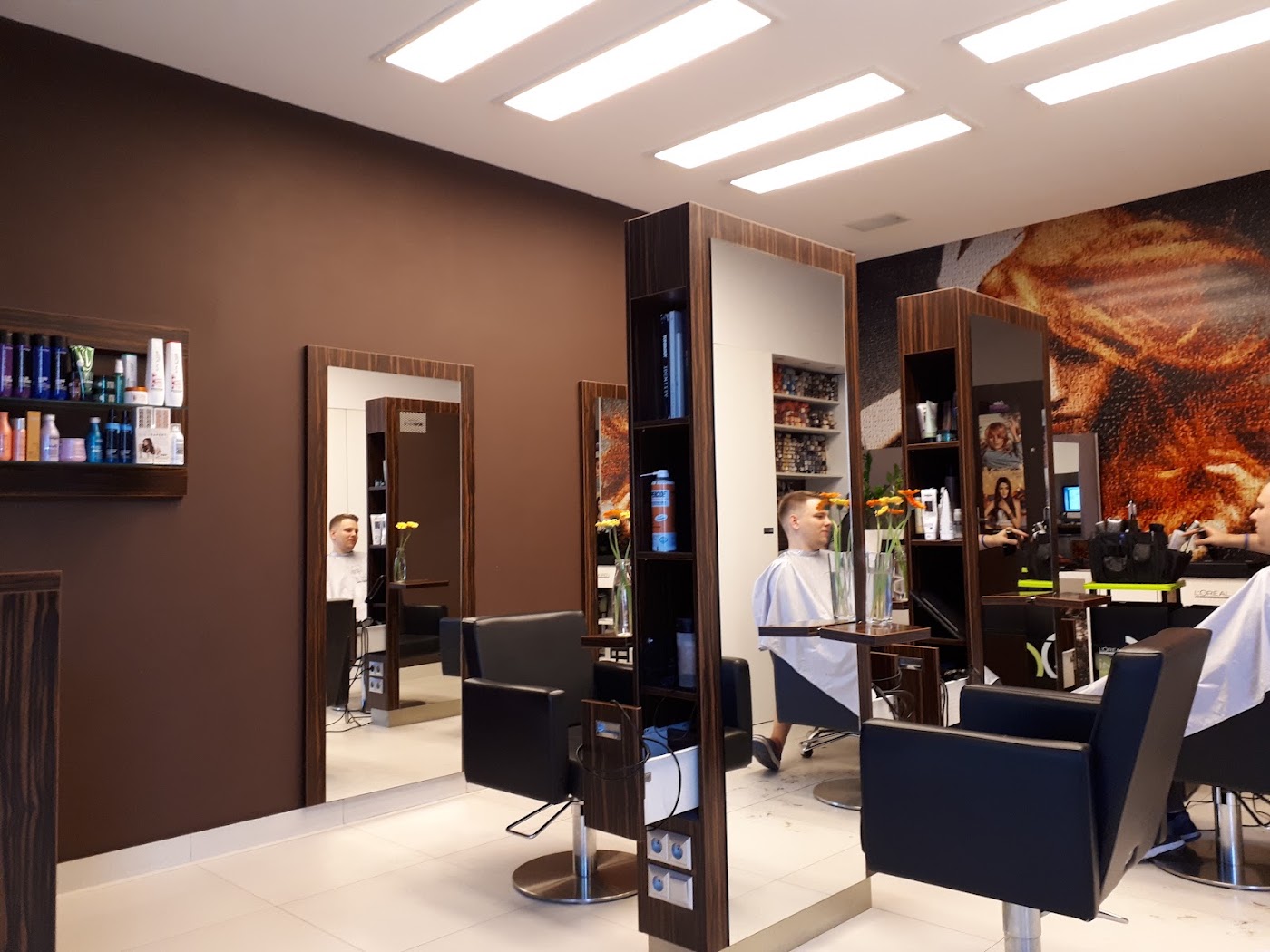 Ciepłe wnętrze salonu z drewnianymi elementami, fotelami i lustrami